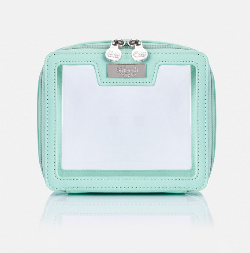 A light green, smooth travel bag with a zipper closure and a brand tag on the side.